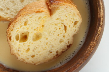 sliced French bread in egg wash for French toast cooking image