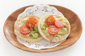 mashed avocado and cherry tomato in English muffin with copy space