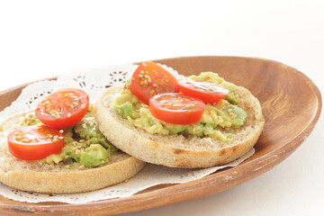 mashed avocado and cherry tomato in English muffin with copy space
