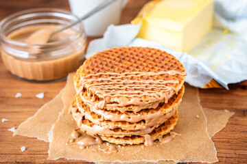 Traditional local authentic Dutch Netherlands sweet fresh homemade tasty stack brown golden waffle melt salted caramel honey syrup for dessert in cafe with hot warm coffee milk tea call Stroopwafel