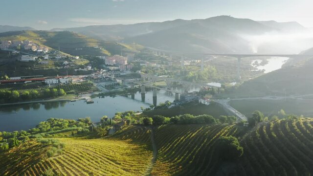 Panoramic view of city Peso da Regua located in green mountains in morning light, Vila Real, Portugal, Europe. Bridges over river situated two parts of city. Wine region in Douro valley, 4k footage