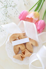 Chinese fortune cookie and message card with flower bouquet and ribbon 