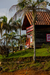 Naklejka premium Tropical beautiful beach house with red and white windows on tropical island with palms on the beach of Caribian sea