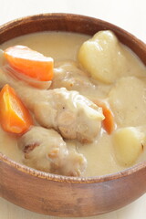 homemade chicken and potato clam stew in wooden bowl