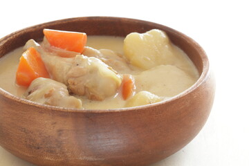 homemade chicken and potato clam stew in wooden bowl