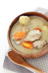homemade chicken and potato clam stew in wooden bowl