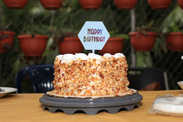 Birthday cake. Almond cake. Cream and almond dessert on terrace table.