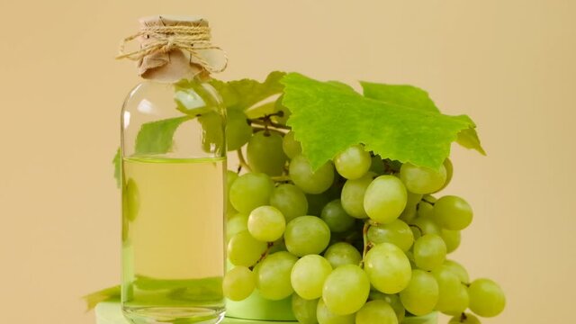 Grape seed oil. bottle and bunch of green grapes. rotation. High quality 4k footage