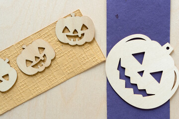 big and small jack o lanterns on a purple and sand paper and wood background 
