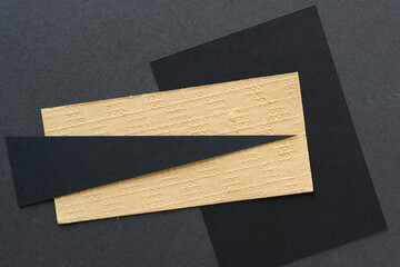 textured ochre and black paper shapes arranged on a dark gray paper background
