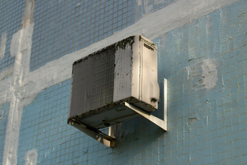 The air conditioning on the wall of the house. A cooling device for climate control.