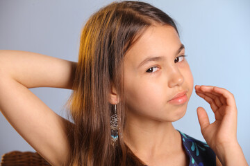 Close-up portrait with hand near face. The portrait shows a beautiful dark-haired teenage girl 12...
