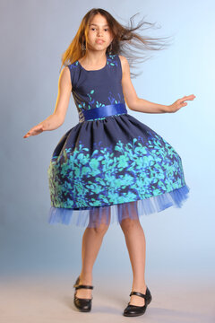 Lovely Skinny Brunette Teenage Girl 12 Years Old In A Blue Dress Is Spinning In Dance.