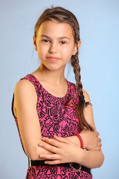 Portrait With Bare Arms Bright Cheerful Cute Dark-haired Teenage Girl 12 Years Old In A Purple Dress.