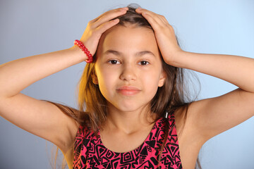 Portrait of a bright cute dark-haired teenage girl 12 years old in a purple dress, she is holding...
