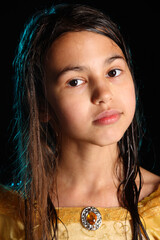 Close-up portrait of a bright cute smart brunette girl 12 years old in a yellow silk dress, she...