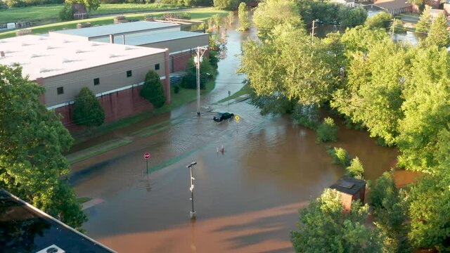 Car drives into flooded street. Dangerous driver behavior. Insurance risk of loss. Aerial view in USA.