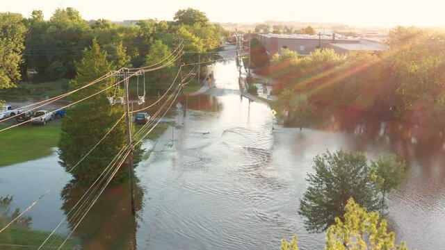 Street flooded in hurricane aftermath in USA. Pedestrian crossing sign submerged in American town. Aerial at sunrise.