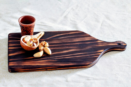brazil nuts in a cutting board with a cup.