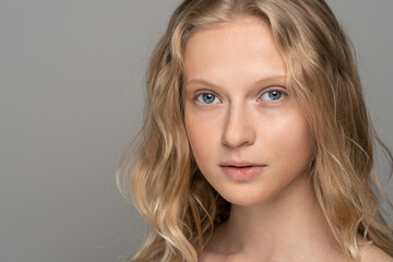 Close up of beauty woman face portrait with blue eyes and curly hair. Spa model girl with perfect...