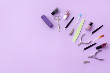 Set of tools for manicure and nail polishes on color background
