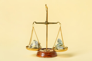 Scales of justice with crumpled dollar banknotes on color background