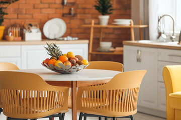 Basket with fresh fruits on dining table in modern kitchen