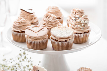 Dessert stand with tasty wedding cupcakes on table