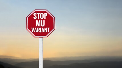Traffic sign: ‘STOP MU VARIANT’ on cement pole beside the rural road with sunset and landscape background, copy space, concept for calling drivers and passengers to stop new variant coronavirus now.