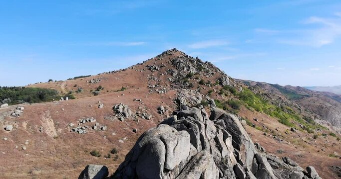 Pricopan Summit With The View Of A Cross In Macin Mountains, Tulcea County, Dobrogea, Romania. Drone Orbit
