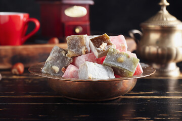 Plate with tasty Turkish delight on black wooden background