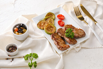 Plate with beef brisket and vegetables on white background