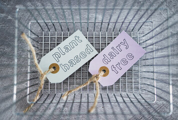 plant-based and dairy-free product tags on top of grocery shopping basket, healthy nutrition and...