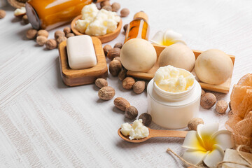 Fototapeta na wymiar Composition with jar of shea butter, nuts and spa supplies on light background, closeup