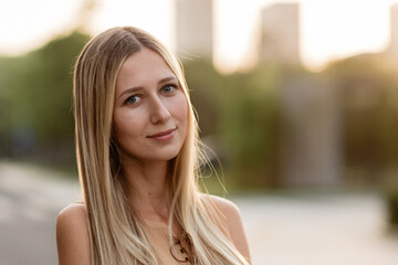 Closeup Portrait of beautiful woman with blonde hair outdoor at hot summer day