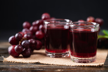Red grape juice in a glass with fresh grape on wooden background, Healthy drink, Still Life