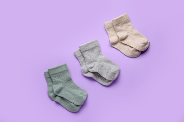 Different baby socks on color background
