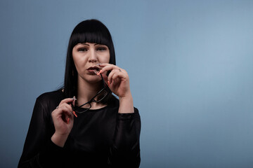 portrait of a beautiful girl with glasses posing for a photographer in the studio