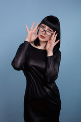 portrait of a beautiful girl with glasses posing for a photographer in the studio