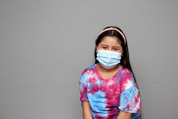 Happy Latin Little Girl Wearing Face Masks To Protect Herself From Coronavirus In The New Normal Due To The Covid-19 Pandemic
