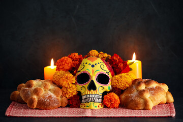 Bread of the dead and painted skull with marigold flowers on dark background. Celebration of...