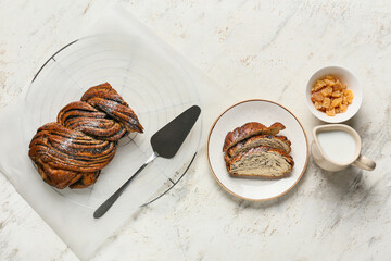 Composition with tasty poppy seed bun on light background