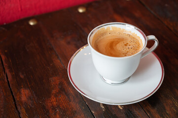 A cup of Masala tea on wooden table. Masala tea is a mixture of many ingredients including ginger, cardamom, cinnamon, cloves, and black pepper.