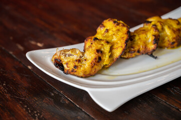 Tandoori Chicken Kebab served on wooden table. Tandoori Chicken Kebab are made with a yoghurt marinade flavoured with Garlic, Ginger, Green Chilli and Spices.