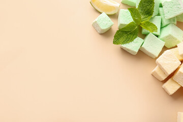 Tasty sweet marshmallows and mint on color background