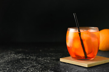 Glass of tasty aperol spritz cocktail on dark background