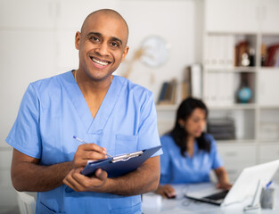 Therapist is standing with documents in clinic