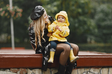 Funny kids in rain boots playing in a rain park