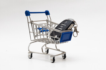 car key in a miniature shopping cart isolated on a white background 