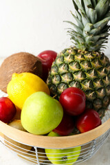 Basket with fresh fruits on light background, closeup